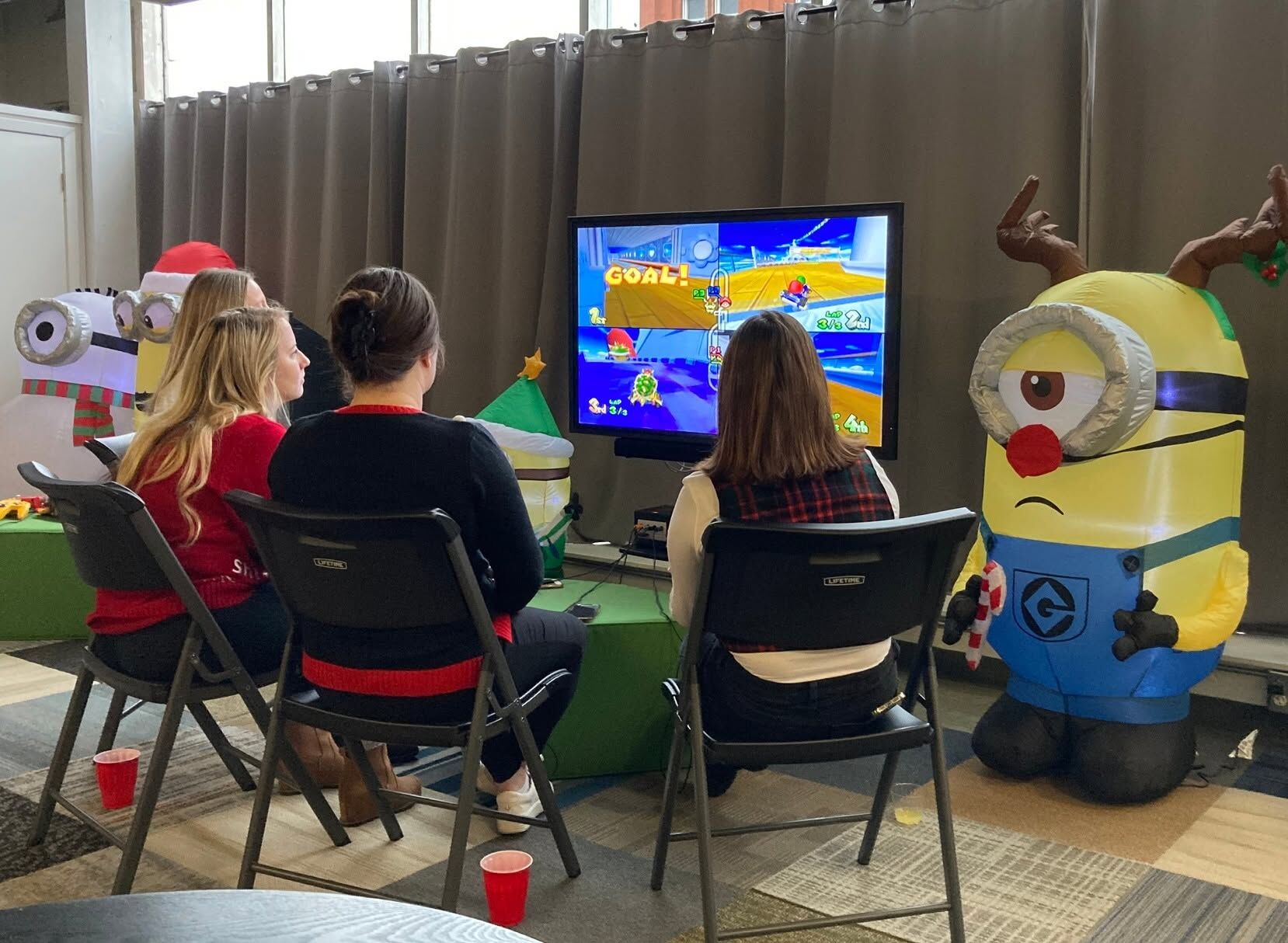 Guests in holiday sweaters playing a console game together
